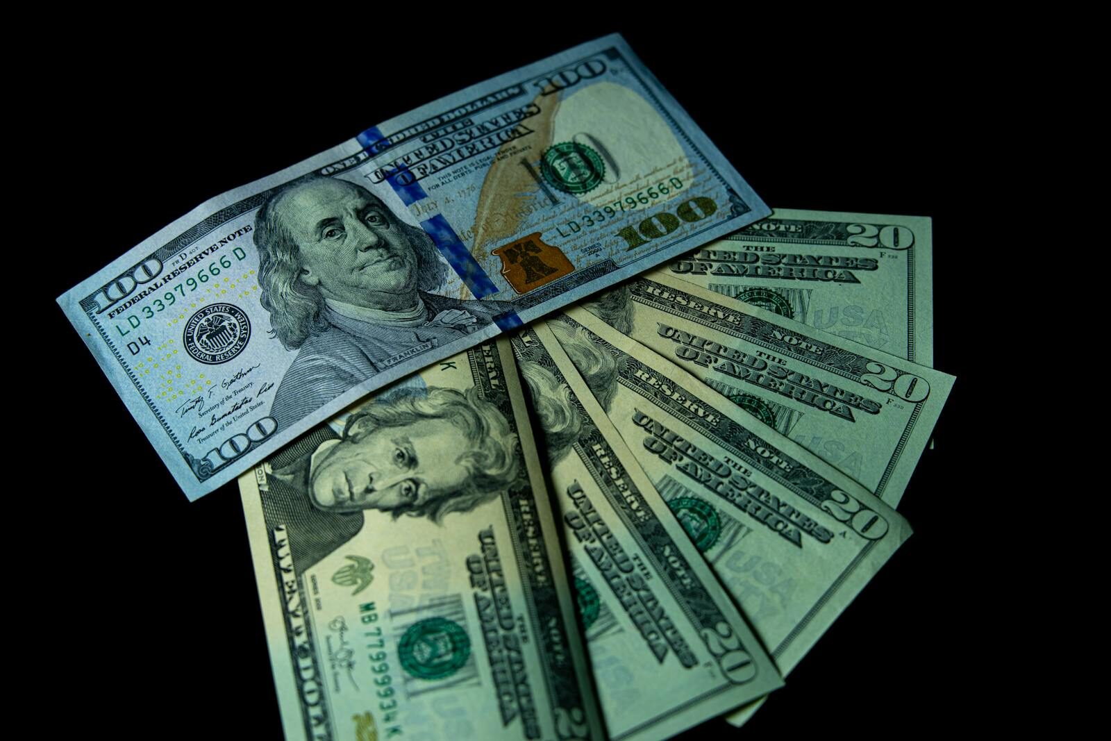 Close-up image of varied US dollar bills on a black background.
